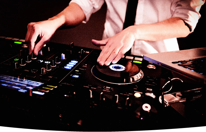 Ein DJ mixt Musik auf einem DJ-Mixer in Landshut oder München.