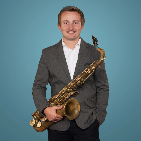 Ein Mann hält ein Saxophon vor einem blauen Hintergrund, perfekt für einen DJ.