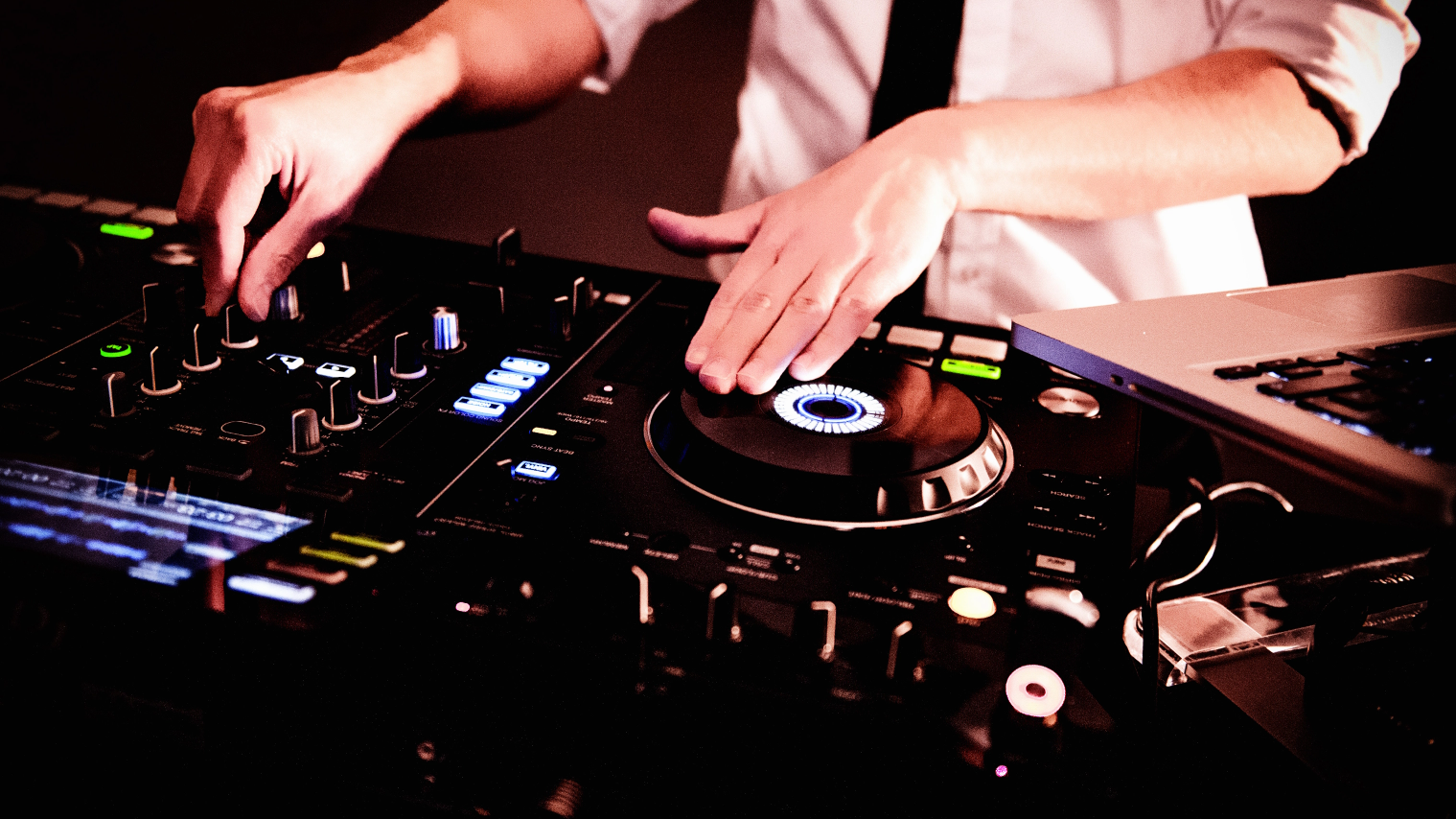 Ein Hochzeits-DJ mixt auf einer Hochzeit Musik auf einem Plattenspieler.
