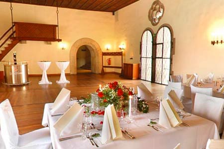 Ein Bankettraum mit weißen Tischdecken und Stühlen, perfekt für Hochzeitsfeiern in Landshut. Ein Bankettraum mit weißen Tischdecken und Stühlen, perfekt für Hochzeitsfeiern in Landshut.