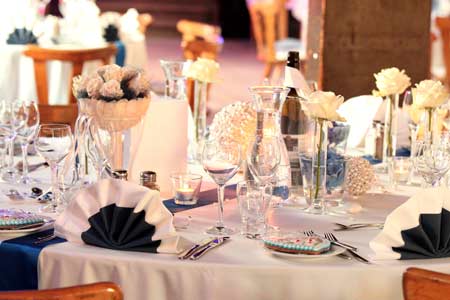 Ein mit eleganter blau-weißer Bettwäsche gedeckter Tisch, perfekt für eine DJ-Hochzeitsfeier in München.