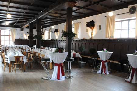 Ein großer Raum mit Tischen und Stühlen, ideal für die Ausrichtung von Veranstaltungen wie DJ-Hochzeiten oder Firmenmeetings.