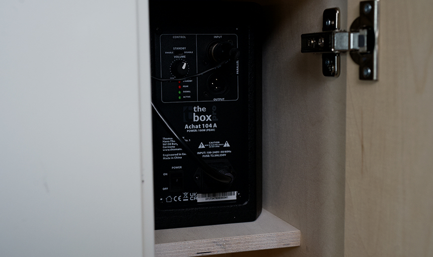 Audiogerät in einem Holzgehäuse mit Bedienknöpfen und Eingangsanschlüssen auf der Vorderseite mit der Aufschrift „The Box Achat 104A“. Audiogerät in einem Holzgehäuse mit Bedienknöpfen und Eingangsanschlüssen auf der Vorderseite mit der Aufschrift „The Box Achat 104A“.