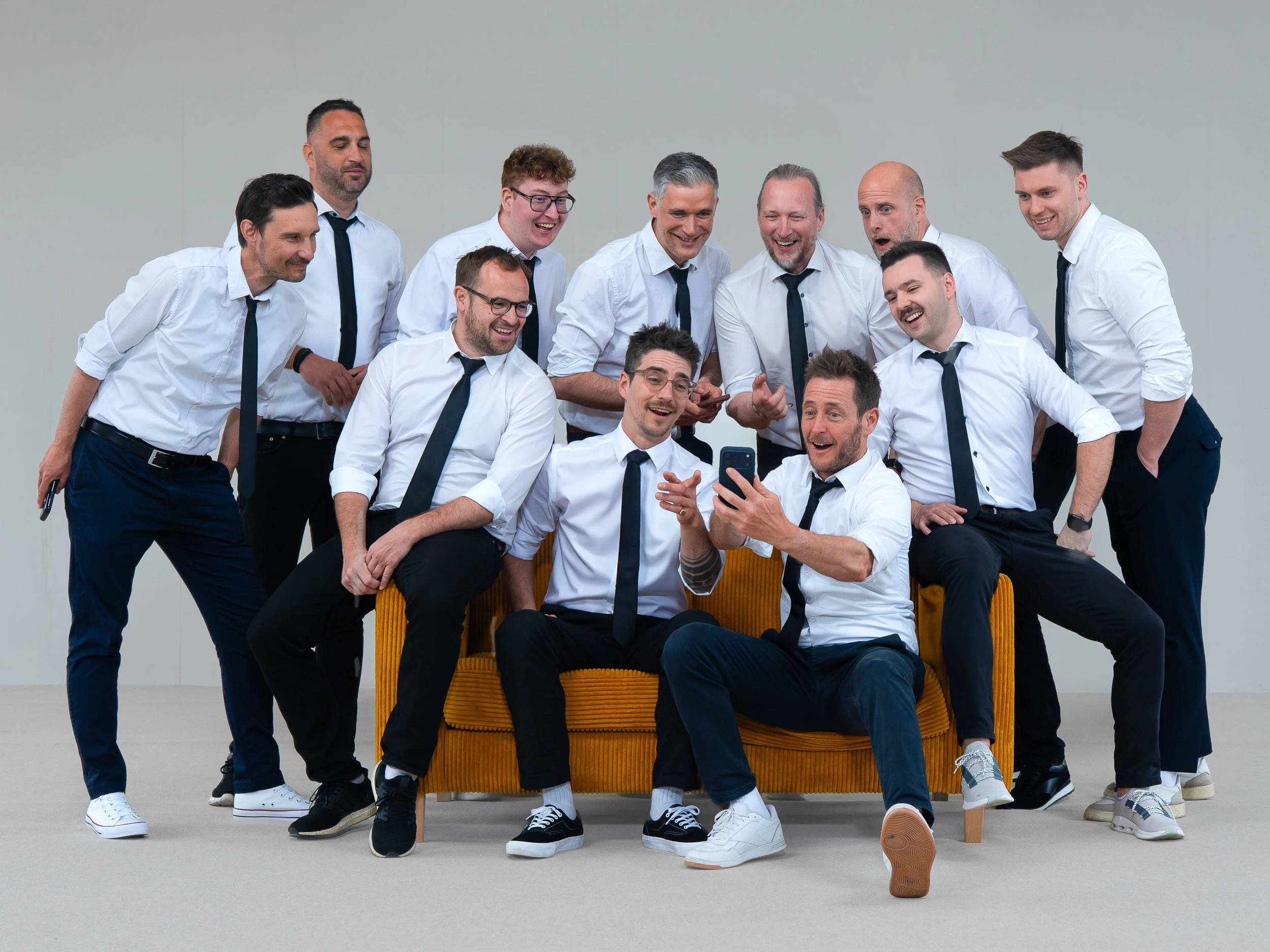 Gruppenbild der Deejays von DooEvents für Hochzeiten, Firmenfeiern und Geburtstage mit einem Handy.
